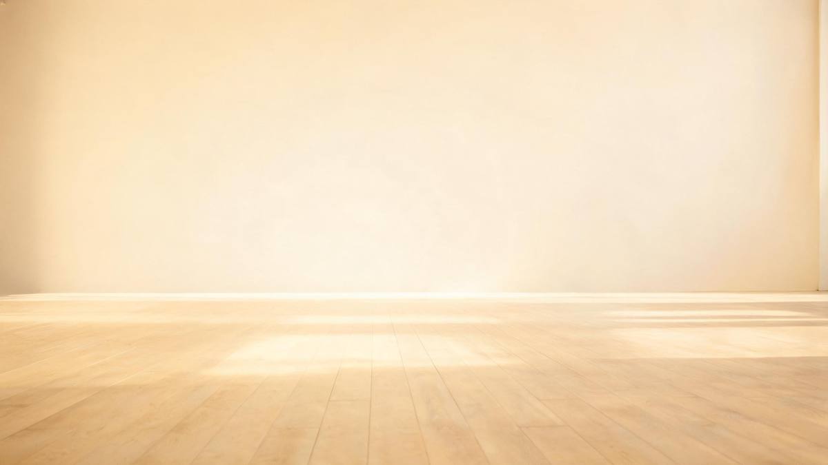 A plain bright studio backdrop with soft even light and an empty floor