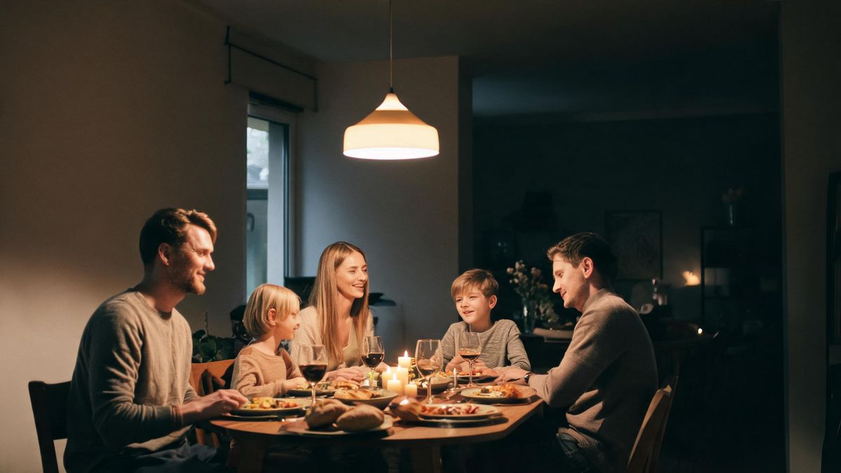 A family gathered around a dinner table in warm interior light, relaxed expressions.