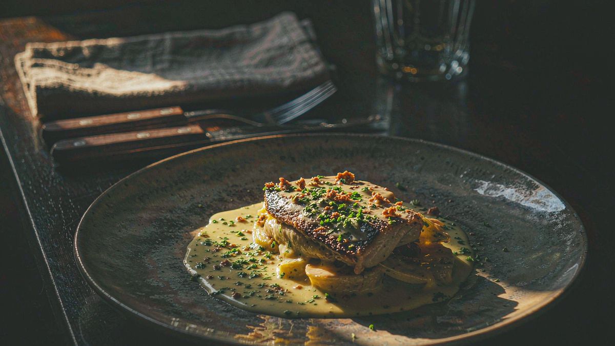 A plated dish photographed from a low angle on a dark ceramic plate
