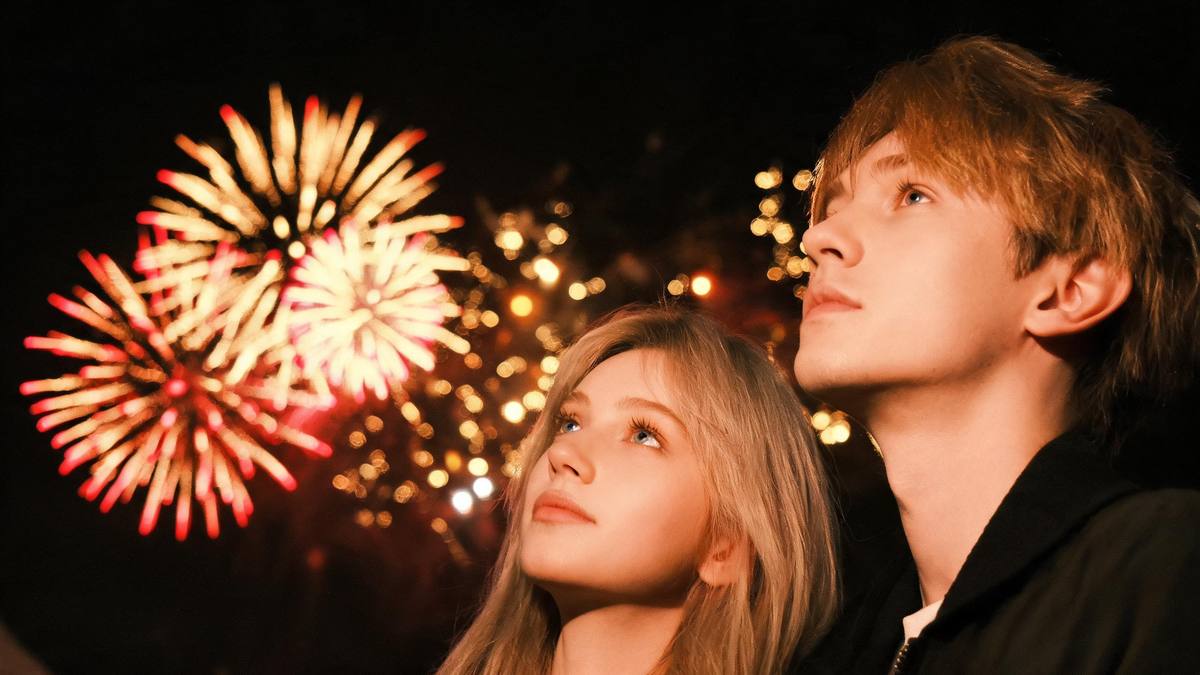 A night sky filled with overlapping fireworks bursts in gold and crimson with no people