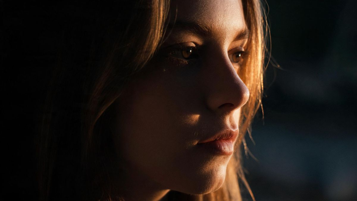 A close study of a face in low-key light, one edge caught by a rim light.