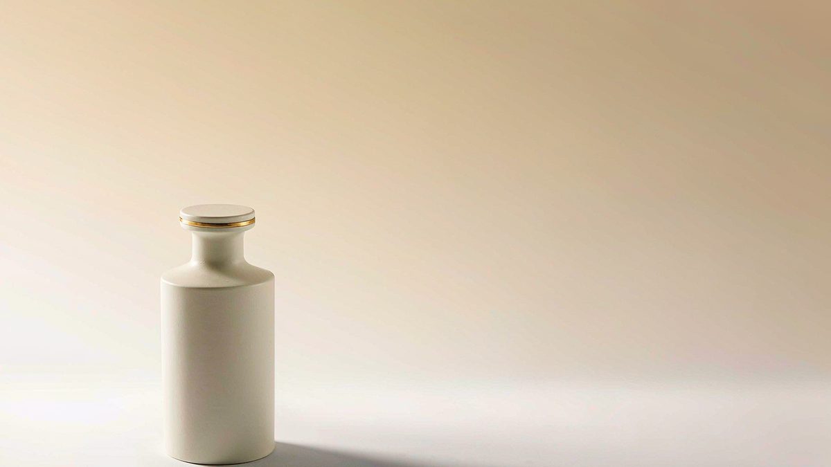 A matte ceramic bottle casting a soft gradient shadow on a seamless warm white backdrop