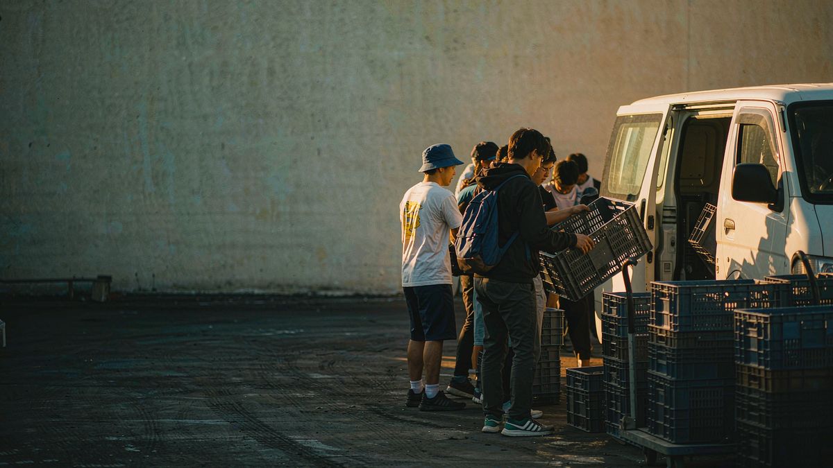 Volunteers loading supply crates into a van at dawn