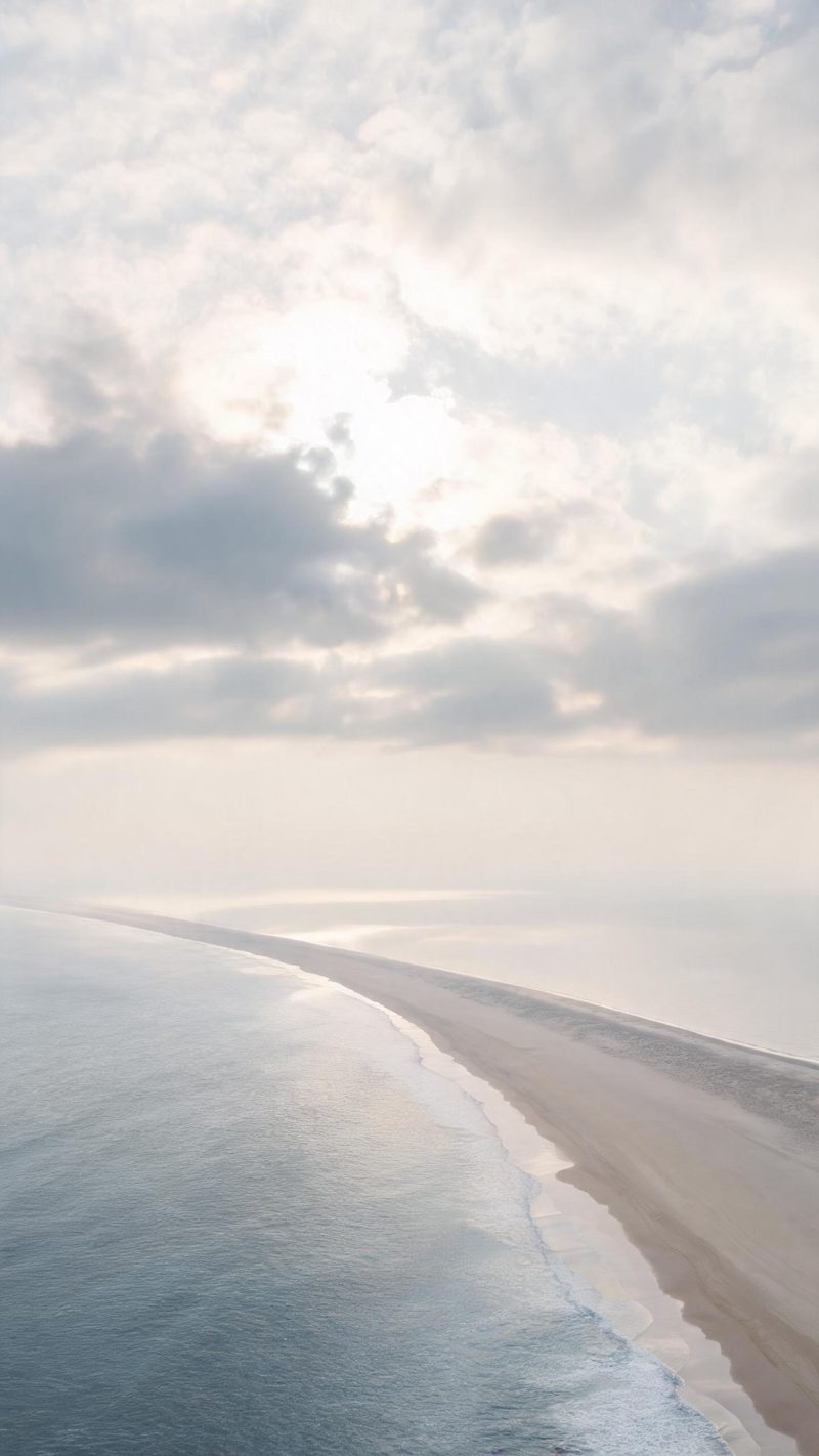 Clouds breaking apart as the camera descends toward a coastline, soft light