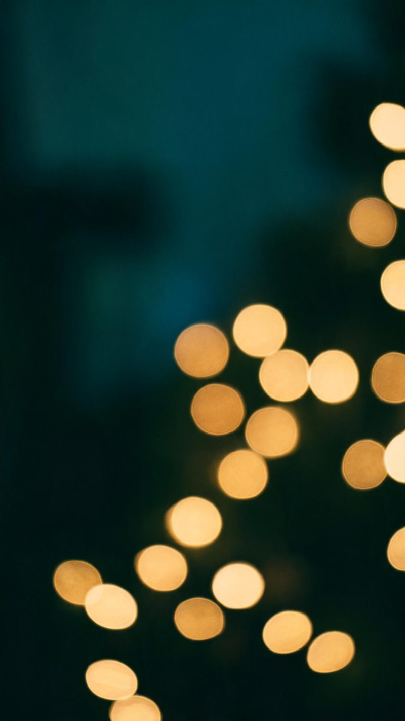 Out-of-focus warm fairy lights filling the frame with deep teal shadow between bulbs