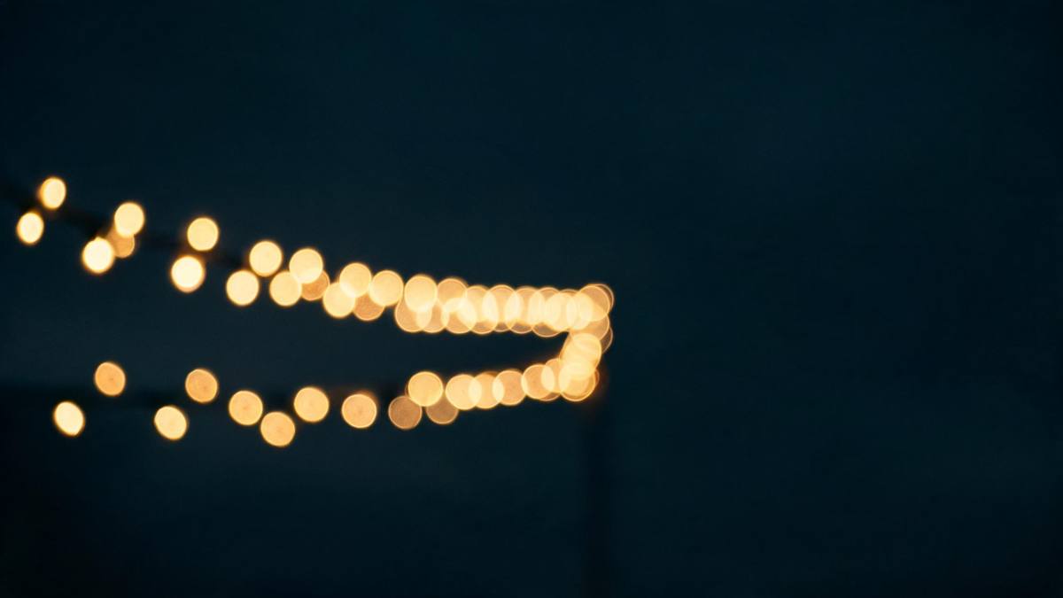 A row of warm fairy lights with soft bokeh against a dark background, no people
