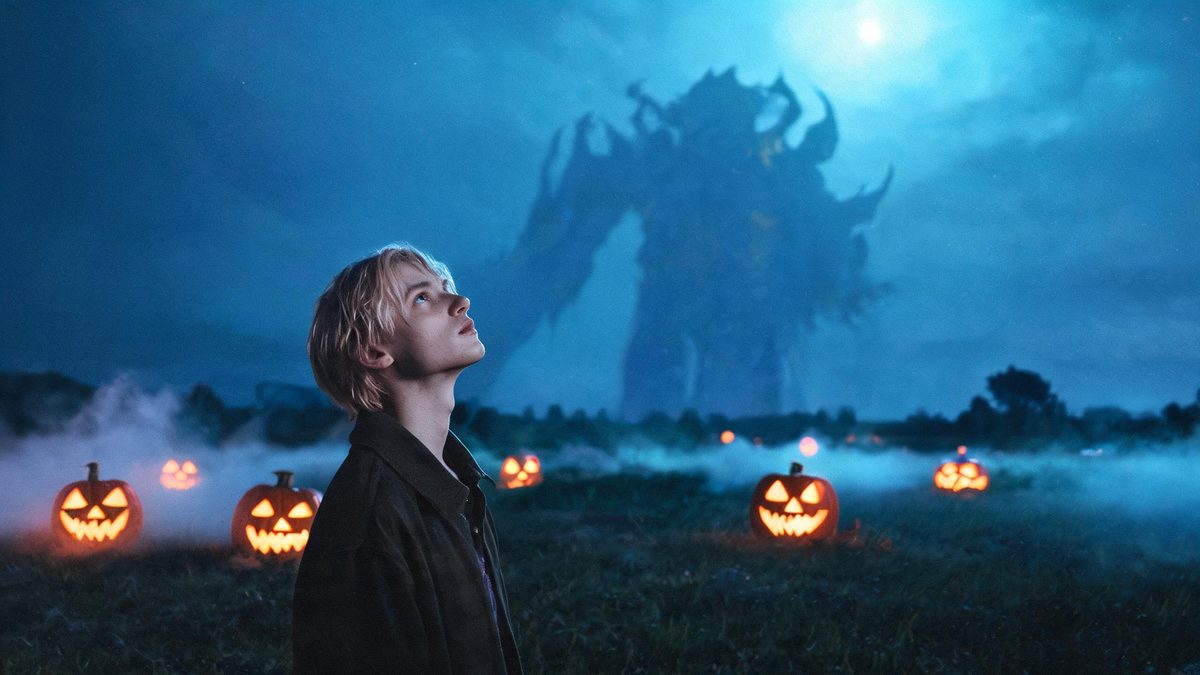 A person standing in an open field looking up as an enormous creature rises above the horizon into a wide sky