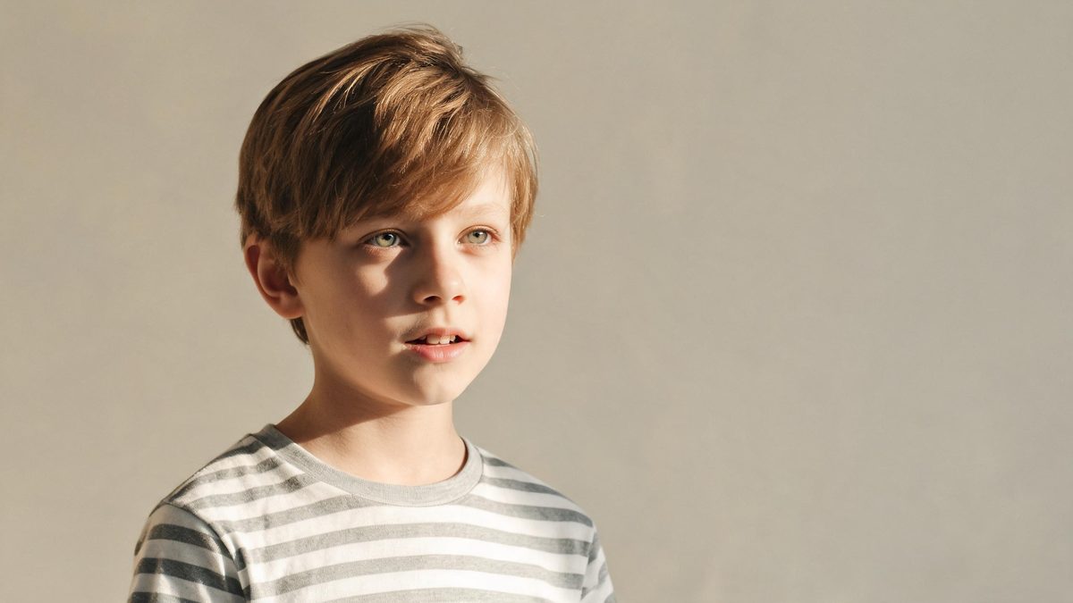 A a child version of the subject on a plain surface, lit from one side with soft shadow, broken apart at the moment of the cut