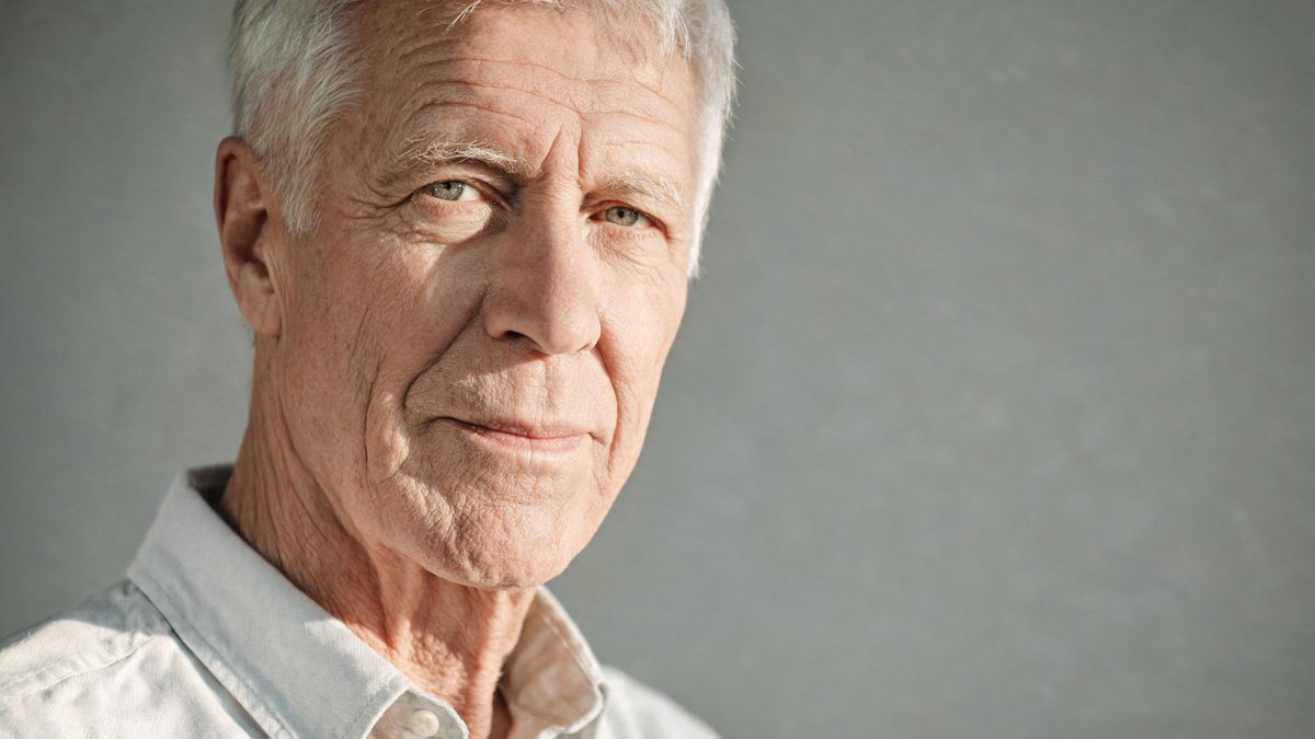 A an older version of the subject on a plain surface, lit from one side with soft shadow, broken apart at the moment of the cut