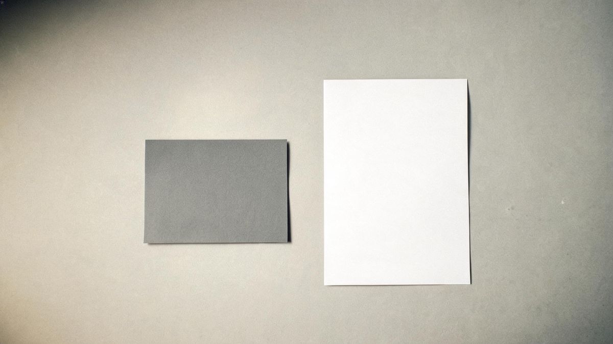 A plain grey colour card and a single print on a studio surface under even soft light