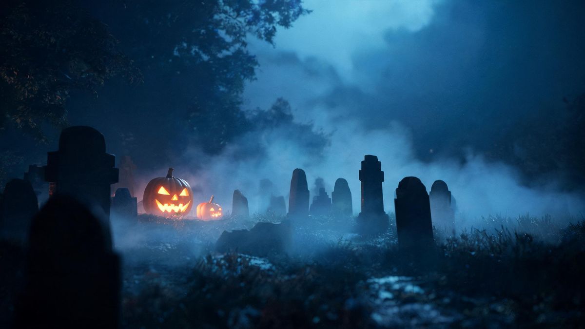 Gravestones as silhouettes in thick night fog under cold blue moonlight