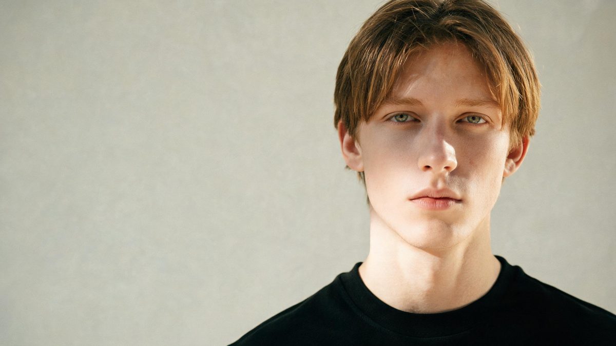 A a dramatic close-up portrait on a plain surface, lit from one side with soft shadow, broken apart at the moment of the cut