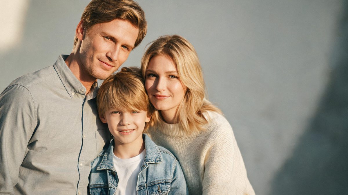 A a family group in one frame on a plain surface, lit from one side with soft shadow, broken apart at the moment of the cut