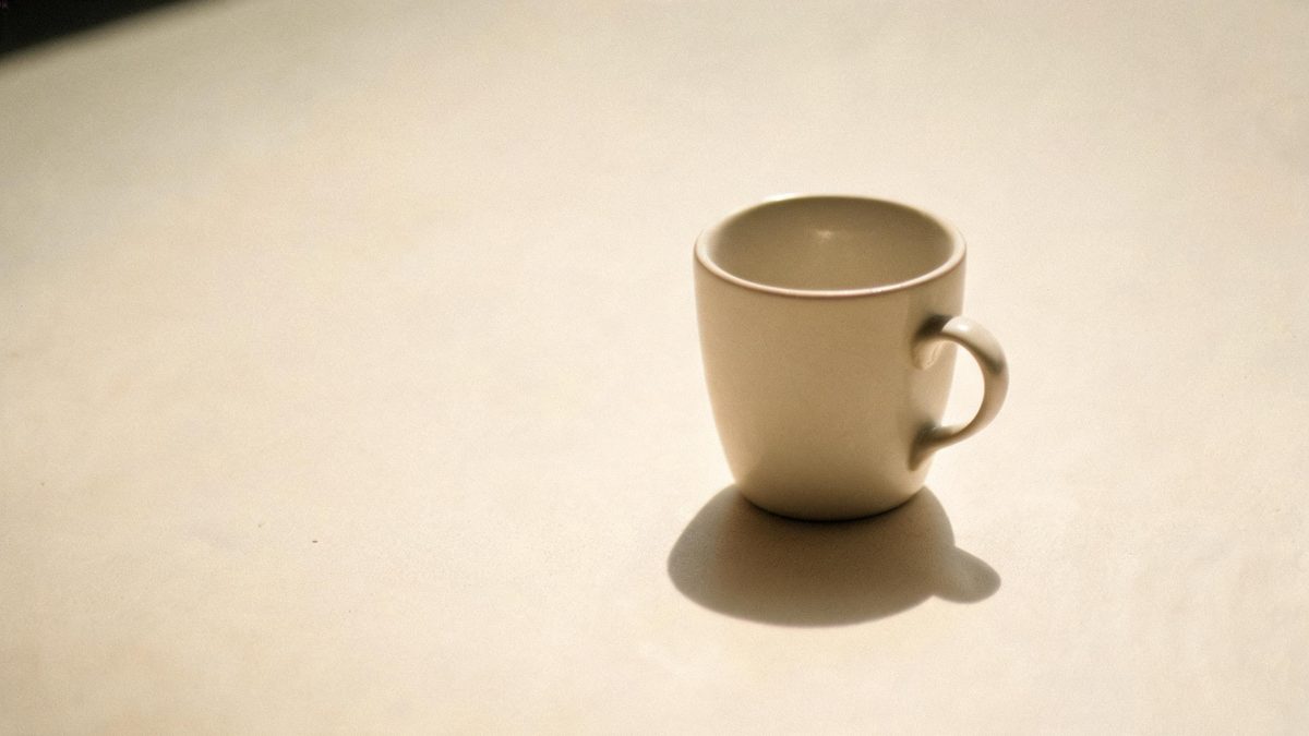 A single everyday object on a plain surface, lit from one side, broken apart at the moment of the cut