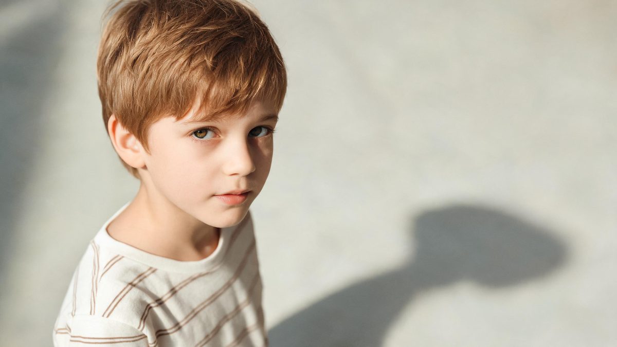 A a child version of the subject on a plain surface, lit from one side with soft shadow, broken apart at the moment of the cut