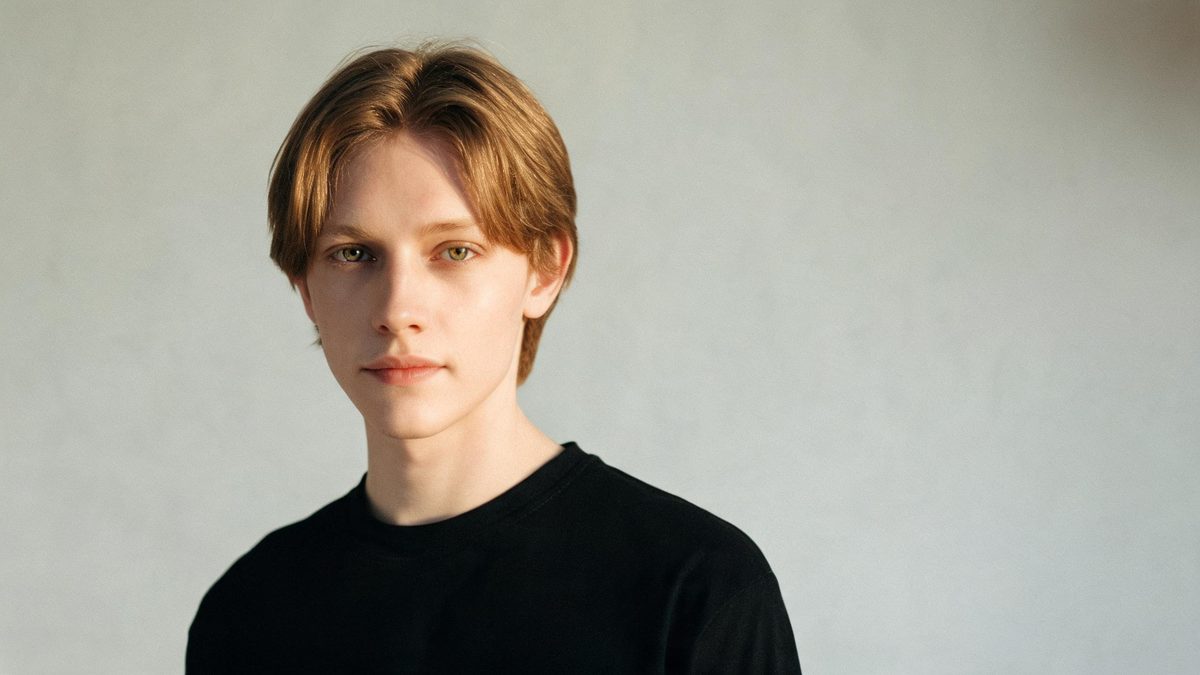 A a magazine cover portrait on a plain surface, lit from one side with soft shadow, broken apart at the moment of the cut