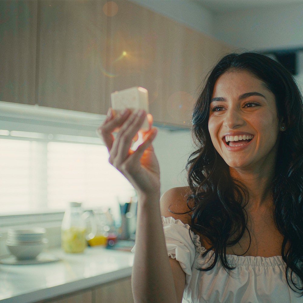A creator filming a product selfie in a bright kitchen, representing the AI UGC video ad generator by OpenFilmo