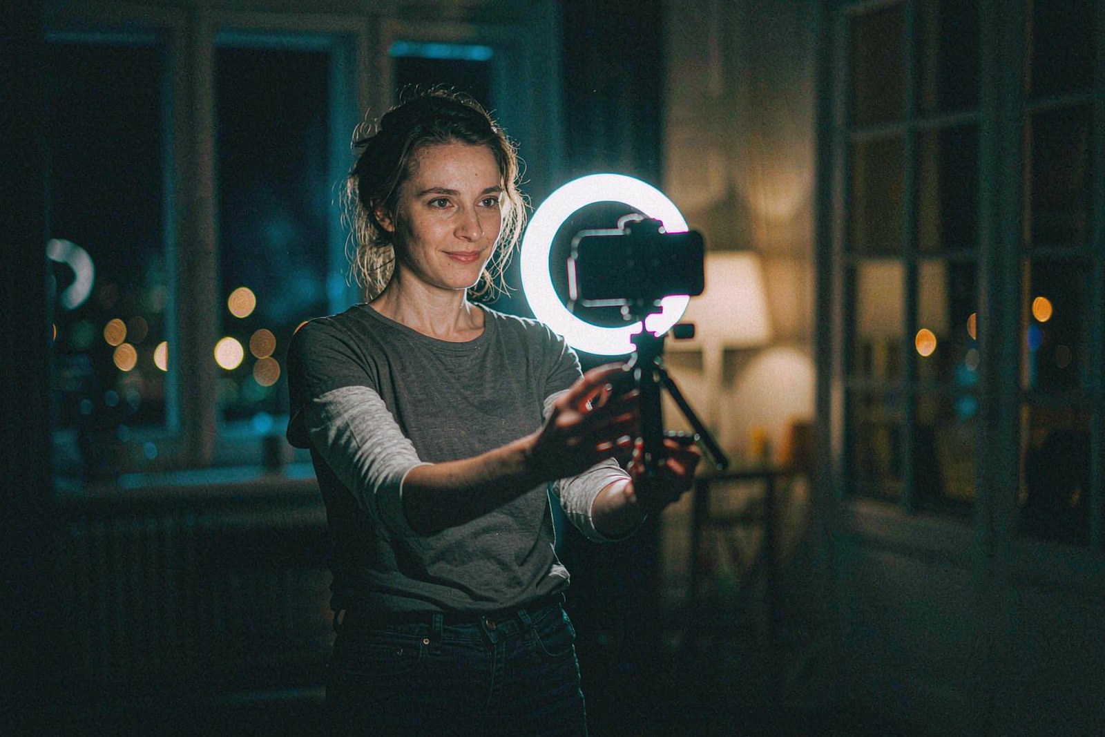 A creator filming a vertical video with a ring light in a dim loft, OpenFilmo AI video studio