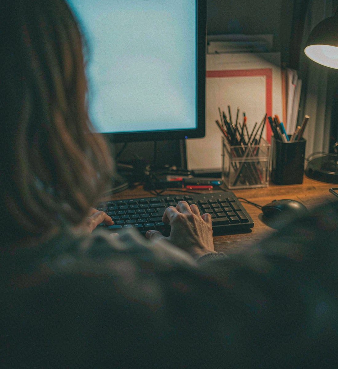 A creator assembling a cut at night, hands on the keyboard, OpenFilmo workflow